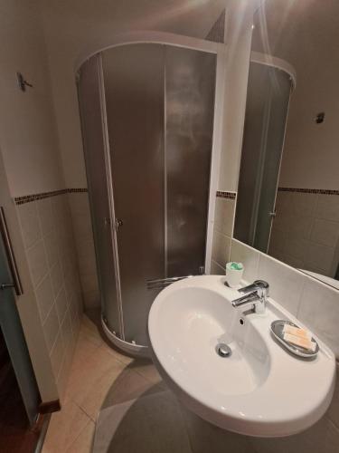 a bathroom with a sink and a shower with a mirror at Affittacamere Penasa in Rabbi