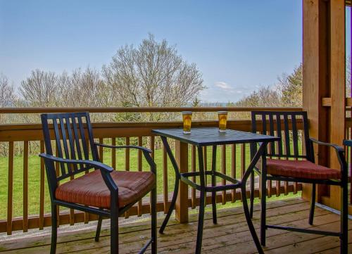 a table and chairs sitting on a deck with a view at Summit 107B 3Br Condo in Snowshoe