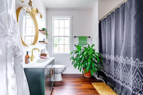 a bathroom with a black shower curtain and a sink at Jungle House Chillicothe - Luxury Downtown Homes Free Parking in Chillicothe