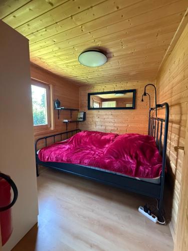 a bed in a room with a wooden ceiling at Eulennest in Reimershagen