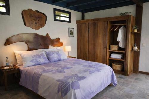 a bedroom with a large bed with a wooden headboard at Uupa Bird Cottage in Moorea
