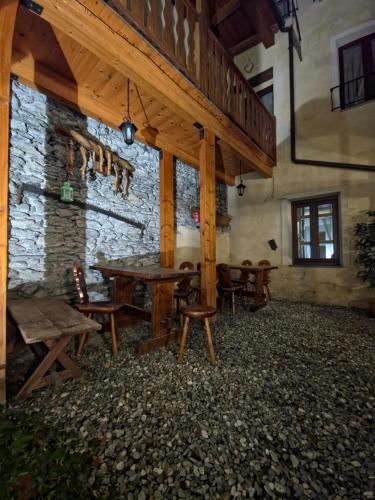 una stanza con tavolo, sedie e un muro in pietra di Hotel Chalet d'Oulx a Oulx