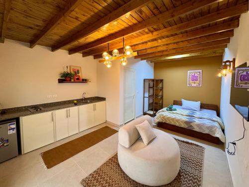 a living room with a white chair and a bed at Zowaar homes in Dahab