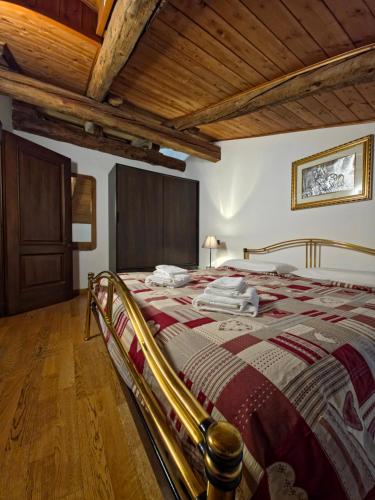 un letto grande in una stanza con soffitto in legno di Hotel Chalet d'Oulx a Oulx