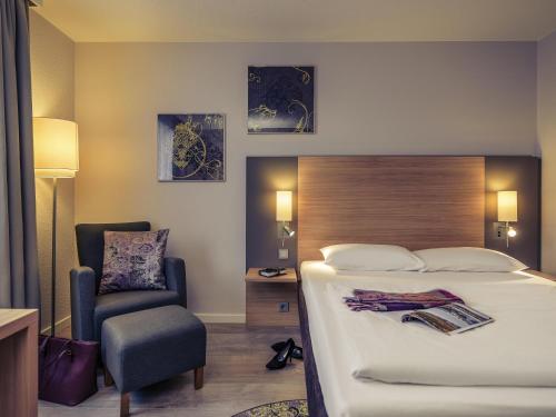 een hotelkamer met een bed en een stoel bij Fürther Hotel Mercure Nürnberg West in Fürth