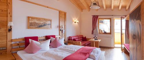 ein Schlafzimmer mit einem Bett mit roten und weißen Kissen in der Unterkunft Hotel Kasimir in Riezlern