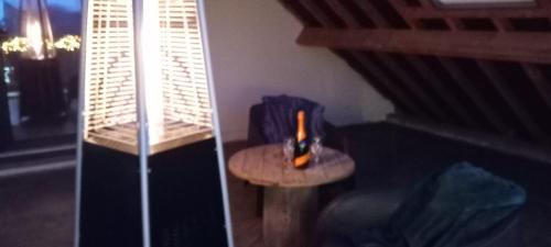 una bottiglia di vino seduta su un tavolo in una stanza di suite Alphonsine a Incourt