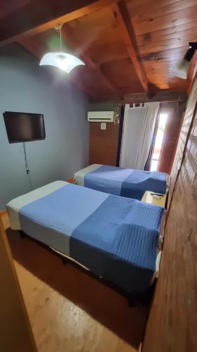 two beds in a small room with a tv at El Pilo in Centenario