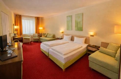 a large hotel room with a bed and a couch at Hotel Phönix in Bad Füssing