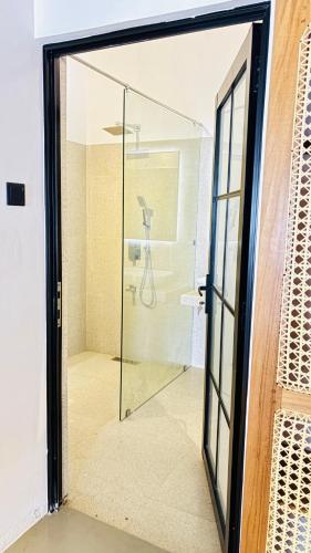 a glass door leading to a shower in a bathroom at Mount Side Hiriketiya in Hiriketiya