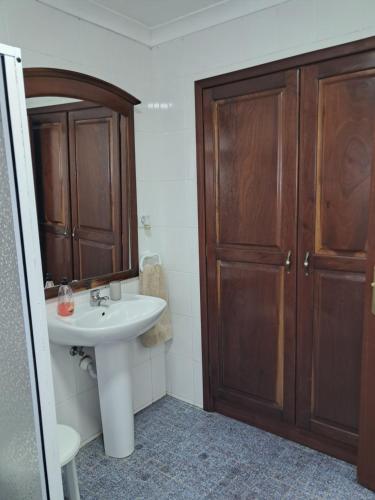 a bathroom with a sink and a wooden cabinet at Casa de Santa Catarina in Cabo da Praia
