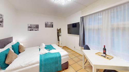 ein Schlafzimmer mit einem Bett und einem Tisch und einem Fenster in der Unterkunft Zentral Altstadt Chur - Bahnhofsnah - Ferienwohnung - Bernina Express - Solution-Grischun in Chur
