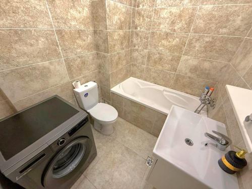 a bathroom with a toilet and a sink and a washing machine at Avangarde City bloc 7 in Roşu