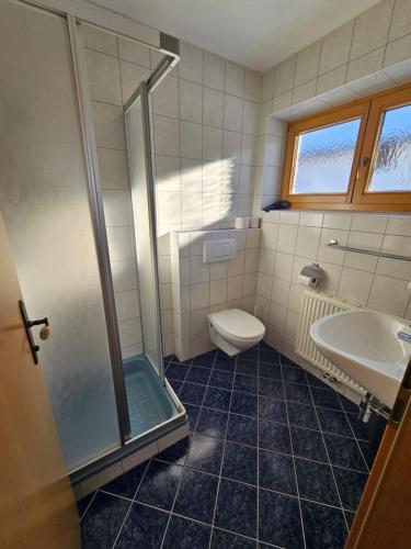 a bathroom with a shower and a toilet and a sink at Haus Bergblick in Obertauern
