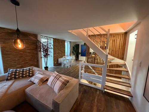 een woonkamer met een bank en een trap bij Ti Eog Glas in Quimperlé