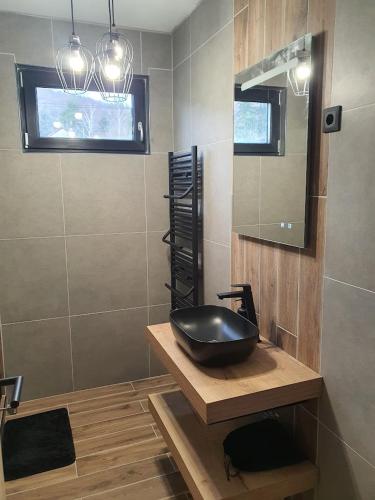 a bathroom with a black sink on a wooden counter at Ohuta-Barn Vendégház in Parád