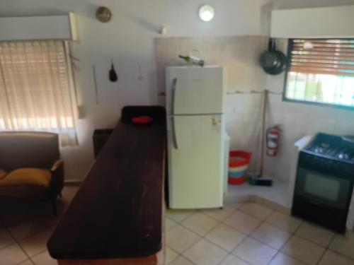 een keuken met een witte koelkast en een tafel bij Casa Monte Hermoso del Este in Monte Hermoso