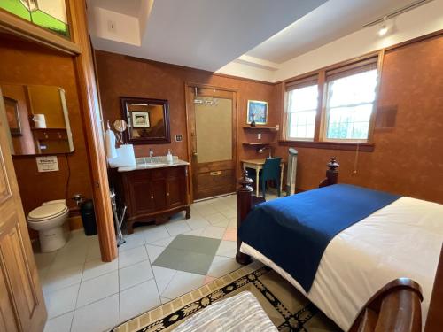 a bedroom with a bed and a bathroom with a sink at Blackbird Glen Bed and Breakfast, Glenmore, Kelowna, BC in Kelowna
