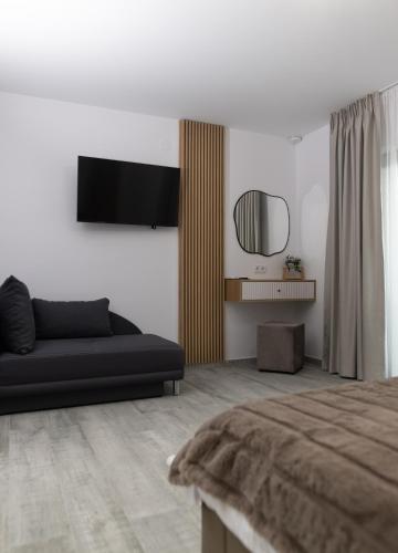 a living room with a black couch and a mirror at Casa de Vacanta Magherus in Topliţa