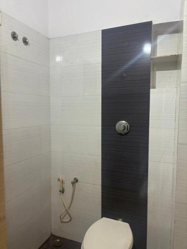 a bathroom with a toilet and a shower at SM Cottage in Mangalore