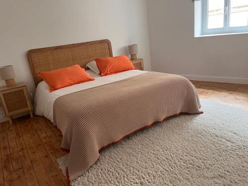 a bedroom with a bed with orange pillows on it at Charmant duplex in Moulins