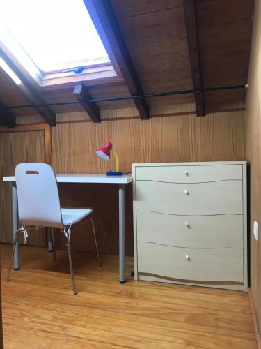 een bureau en een stoel naast een dressoir bij Casa cidade e piscina in Coimbra
