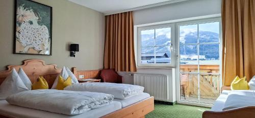 a hotel room with two beds and a large window at Urlaubsland Sonnfeld in Flachau