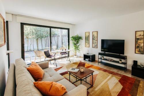 a living room with a couch and a tv and a table at Beautiful 36m2 studio apartment & 50m2 terrace in Cannes