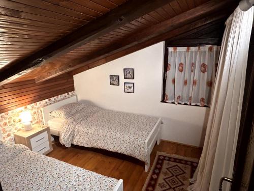 a bedroom with two beds and a wooden ceiling at Wellness house Svjetlost in Jahorina