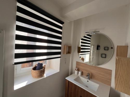 a bathroom with a sink and a mirror and a window at Charmant duplex in Moulins