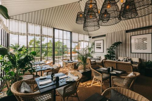 a restaurant with tables and chairs and windows at Torel Palace Lisbon in Lisbon