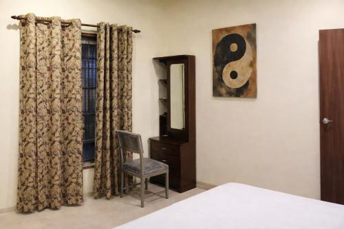 una camera da letto con un letto, una sedia e uno specchio di Kiashna Villa 32 a Khardi