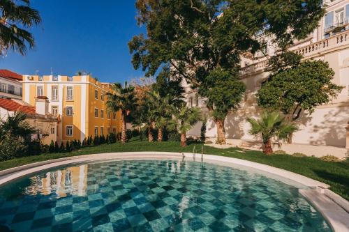 a swimming pool in front of a building at Torel Palace Lisbon in Lisbon