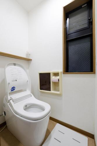 a white toilet in a bathroom with a window at Tokyo My Home Private Room for 3 Guests near Shinjuku Shared Facilities in Tokyo