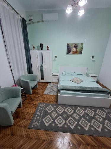 a bedroom with a bed and a chair at Art Nouveau Aparthotel in Oradea