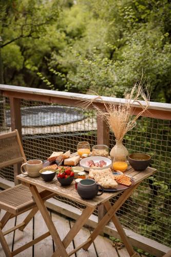 a picnic table with food on it on a deck at Idylle du Causse in Cénevières