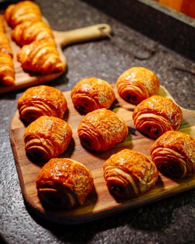 un tagliere di legno con croissant e altri dolci di Zendaya Resort Beach Sport & Spa a Búzios