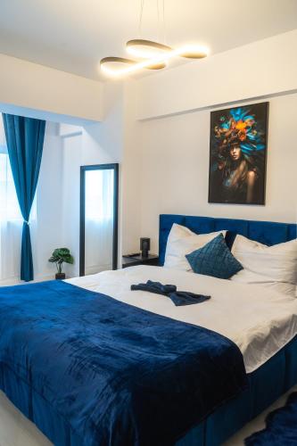 a bedroom with a large bed with a blue blanket at Royal Blue Iasi in Iaşi