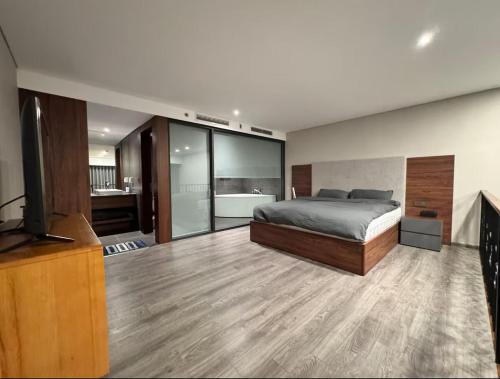 a bedroom with a bed and a television and a bathroom at Solari 15F Duplex Suite with Nhat Tan Bridge View in Hanoi
