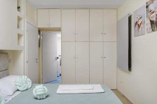 a bedroom with white cabinets and a blue table at Glyfada Cove Apartments-Ostria in Athens