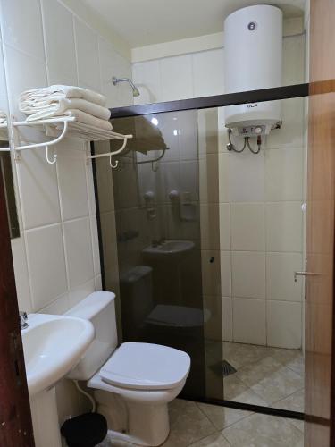 a bathroom with a toilet and a sink at Hotel San Andres in Coronel Oviedo