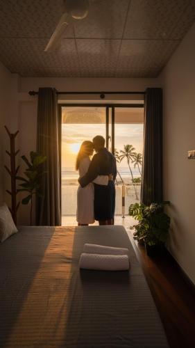 a man and a woman standing in front of a window at Lucky Wave Beach Resort in Colombo
