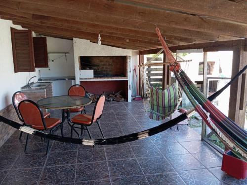 een kamer met een hangmat en een tafel en stoelen bij Casa en el Chuy in Barra del Chuy