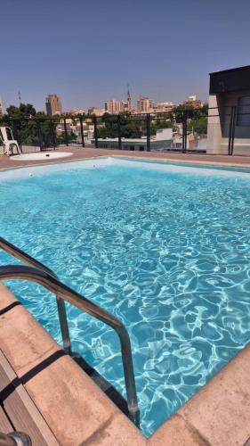 duży niebieski basen na szczycie budynku w obiekcie DAKAR HOTEL w mieście Mendoza