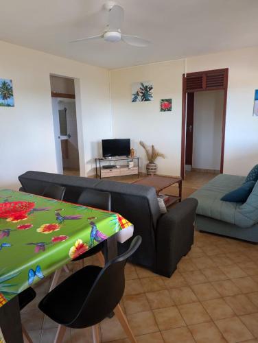 un soggiorno con un divano e un tavolo di Location Hibiscus a Pointe-Noire