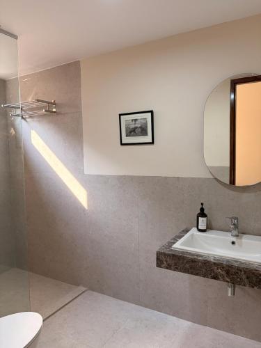 a bathroom with a sink and a mirror at The Pavilion at Riverside Park in Kāundia