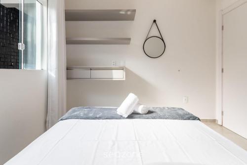 a white bedroom with a bed and a mirror at Apartment 100m from Tabuleiro Beachfront CIR0102 in Barra Velha