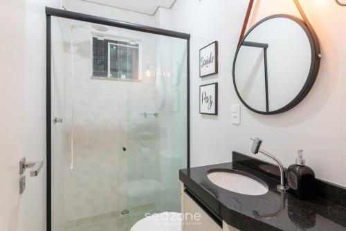 a bathroom with a shower and a sink and a mirror at Apartment 100m from Tabuleiro Beachfront CIR0102 in Barra Velha
