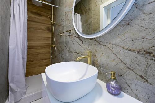 a bathroom with a white sink and a mirror at Apartman Roso in Orebić