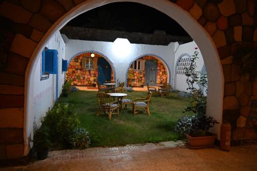 einen Torbogen mit einem Tisch und Stühlen im Hof in der Unterkunft Hllol Hotel Abu Simbel in Abu Simbel
